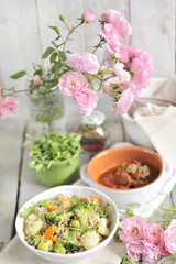 a lunch of vegetable salad, on a table with a bouquet of garden roses. Food for vegetarians. Wessen Lunch