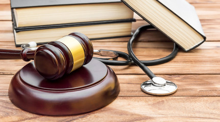 Gavel with stethoscope and books on the table.