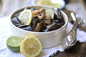 pasta black with seafood, mollusks and seashells. shrimp and sauce. In the vintage style. In Italian ceramics,