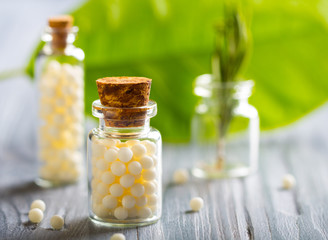 Homeopathy pills bottle wooden eco green leaf background