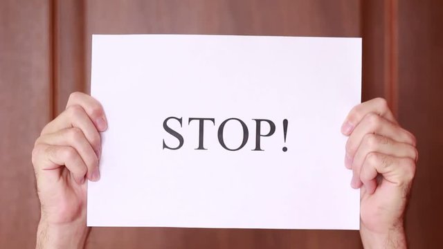 Holding "Stop" sign on paper