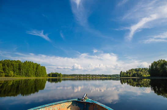 View from a boat on a lake in wild Russian land. Clouds and reflections.