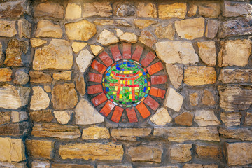 Circular mosaic religious symbol of Shinto on stone wall.