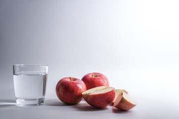 Glass of water with red apples