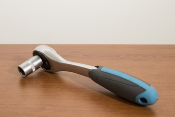 Tools, blue ratchet wrench and accessories on a wood table