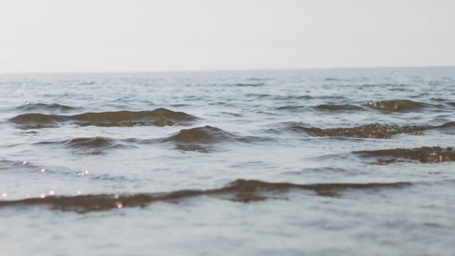 Slow motion handheld closeup of small waves on a beach