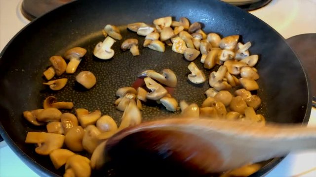 Cooking champinions in a frying pan