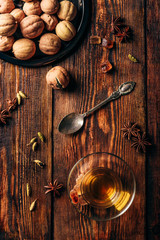 Arabic tea with different spices in armudu glass over wooden surface. View from above