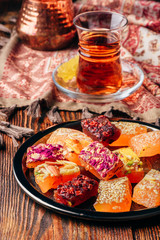 Oriental delight rahat lokum with tea in armudu over tablecloth with ornament
