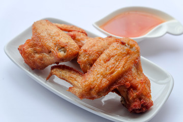 Top view and close up: Deep Fried Chicken wing in white plate with sweet sauce on wooden background. Popular food for kids.