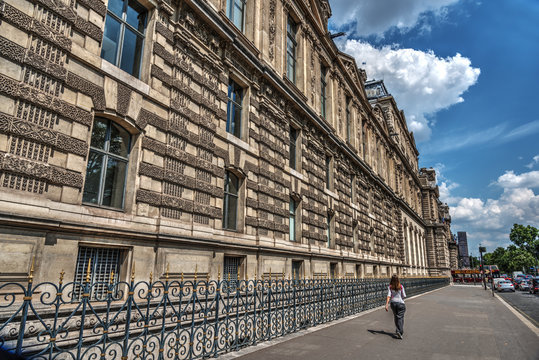 Woman walking by world famous Louvre museum