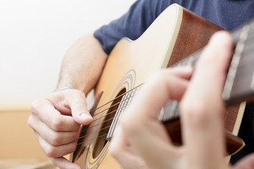 Hands Playing Music with an Acoustic Guitar