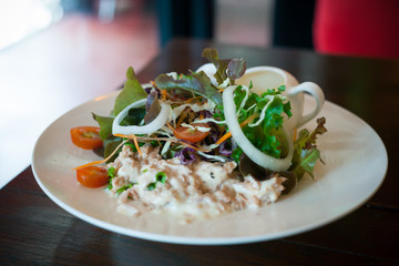 Tuna salad in white dish on dark wood table | Food photograph