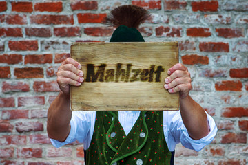 bavarian man holding sign with the german word for good appetite