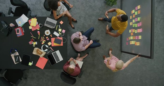 young diverse business people working in office discussing strategy businessman brainstorming successful solution happy colleagues cheering celebrating teamwork success top view 