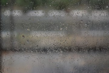 Raindrops flow down the window, leaving patterns on the glass.