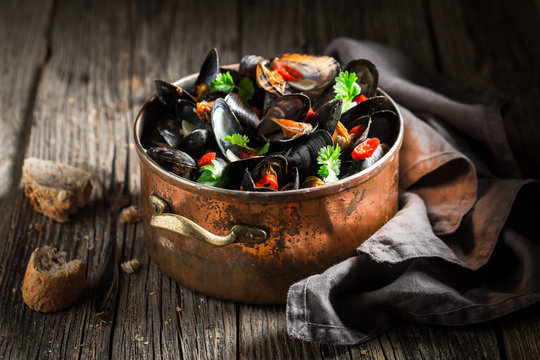 Mussels served with wholemeal bread on wooden table