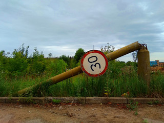 The fallen concrete column with a traffic sign "speed limit".