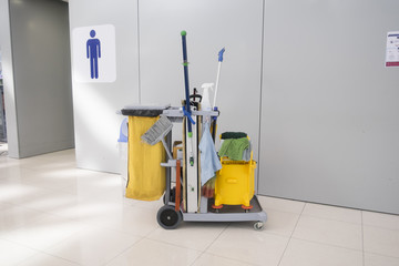 Cleaning cart at front of  men toilet