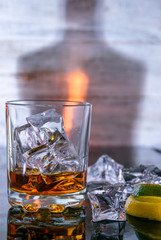 a glass of ice and a bottle of beverage, lime and lemon