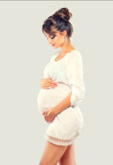 Pregnant happy woman touching her belly. Pregnant beauty young mother portrait, caressing her belly and smiling. Healthy pregnancy concept