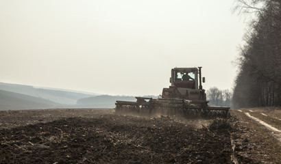 Fototapeta premium Harrowing the soil with disc harrows