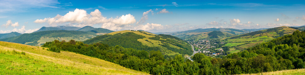 Obraz premium panorama of beautiful mountainous rural area. village down in the valley. agricultural fields on hills