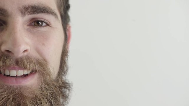 close up young man hipster beard smiling happy wearing nose ring on white background half face