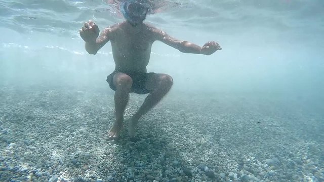 Young man diving with mask on paradisiac beach