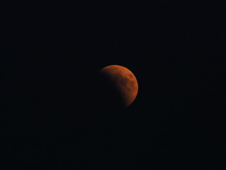 The Blood Moon during longest total Lunar Eclipse of XXI century on black sky seen from Poland in...