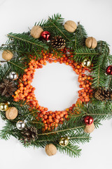 Fototapeta na wymiar Christmas composition. Wreath made of christmas tree branches and red berries on white background. Flat lay, top view, copy space, circle