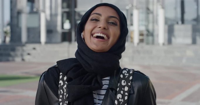 portrait beautiful young muslim woman student laughing enjoying successful college education lifestyle in city wearing hijab