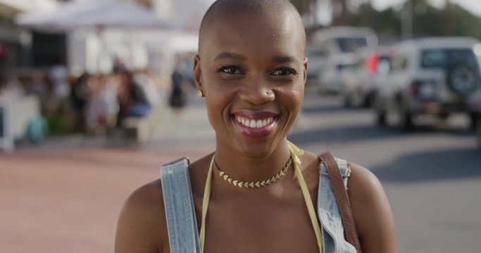 portrait of happy african american woman smiling enjoying independent lifestyle on summer vacation in warm sunny beachfront street real people series