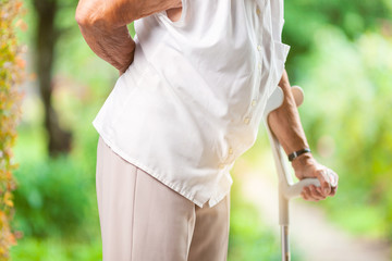 Elderly woman outdoors with back pain