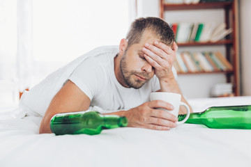 Young man in bed the morning after night out drinking