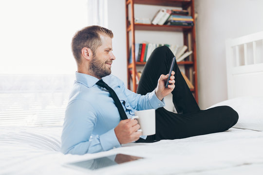 Businessman working from a hotel room with his mobile phone
