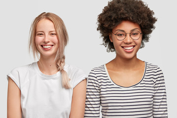 Multiracial lesbian couple have positive expressions. Happy young blonde European woman and her...