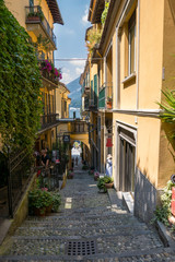 Narrow alley of Bellagio leading to the lake, in the background a glimpse of the lake