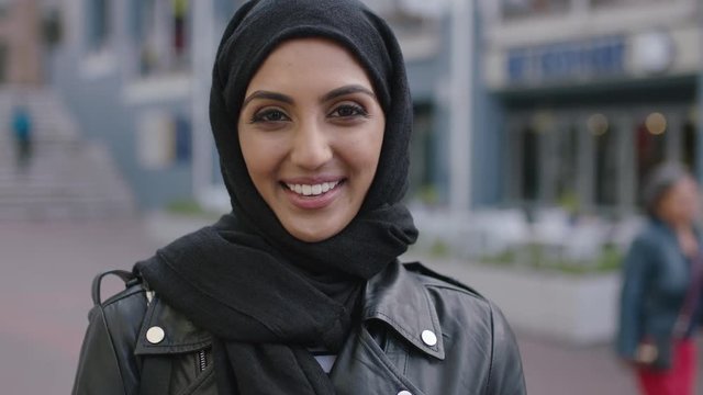 portrait of young muslim woman laughing happy enjoying city life wearing leather jacket