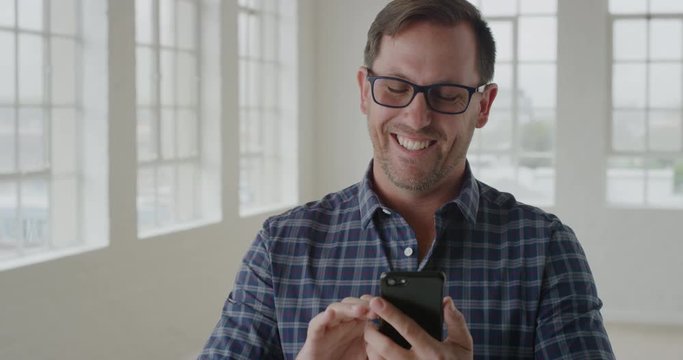 portrait of entrepreneur man using smartphone texting browsing sending messages on mobile phone technology business networking in office apartment