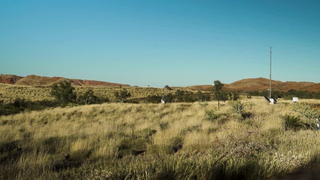 Helicopter taking off from a clearing on a sunny afternoon in the Pilbara of Western Australia