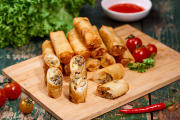 Vietnamese food. Delicious homemade spring rolls on wooden table.
