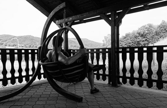 Man Sitting On Rocking Chair On Porch Relaxing