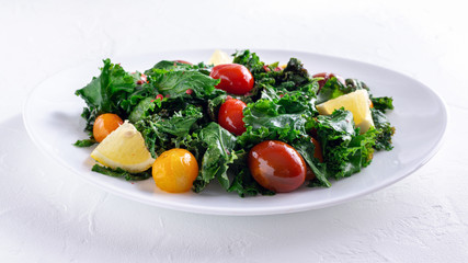 Roasted cabbage with kale and cherry tomatoes and lemon slices