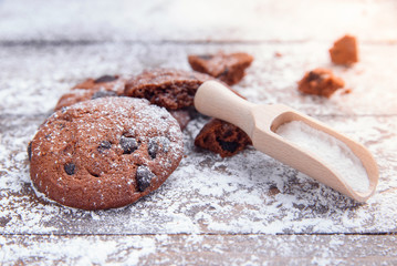 Shortbread cookies with chocolate chips on wooden background sprinkled with powdered sugar. Fresh...