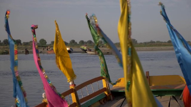 SLOW MOTION shot of flags on boats on the Yamuna River in Vrindavan India