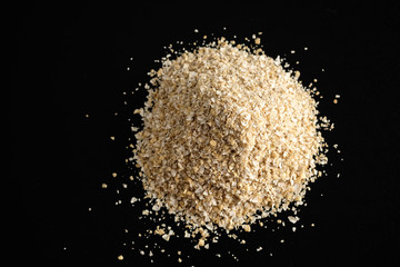 Large size oat bran, useful, cleansing, for a healthy diet on a black background