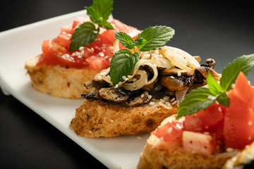 Fresh bruschetta assorted. Serve on a white plate. Order in the menu