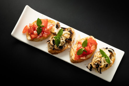 Fresh bruschetta assorted. Serve on a white plate. Order in the menu. View from above.