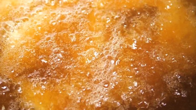 Sliced French fried with oil in big pan, slow motion